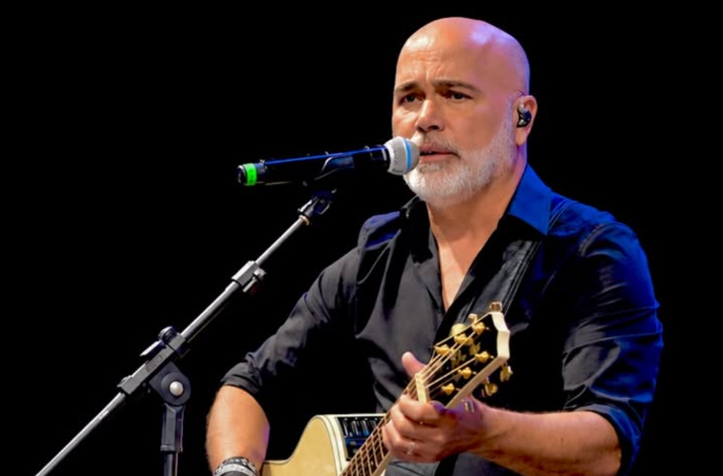 Rick Sollo cantando ao microfone em apresentação musical